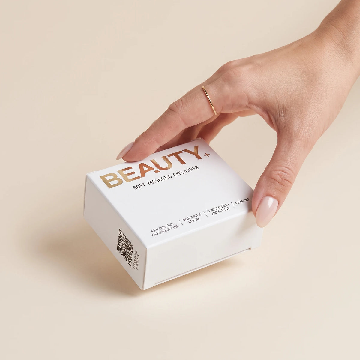 Hand holding a white soft magnetic eyelashes box with rose gold lettering