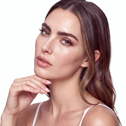 Brunette model with freckles wearing SKY.1 Natural magnetic lashes, close-up portrait